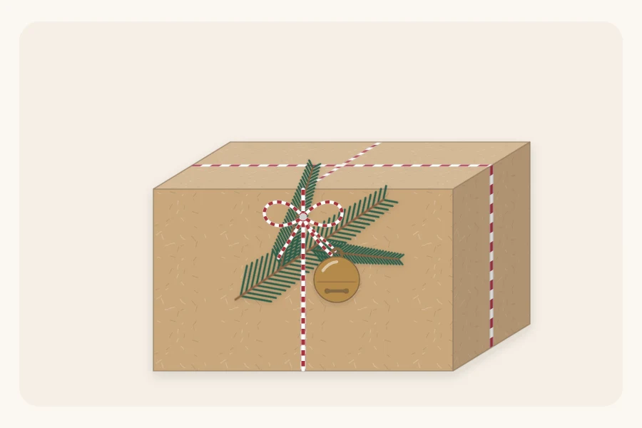 A kraft-wrapped gift with an evergreen sprig, a small round bell and red-and-white baker's twine