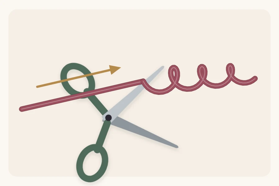 Curling ribbon pulled across the open blade of scissors, the pulled end forming a spiral curl