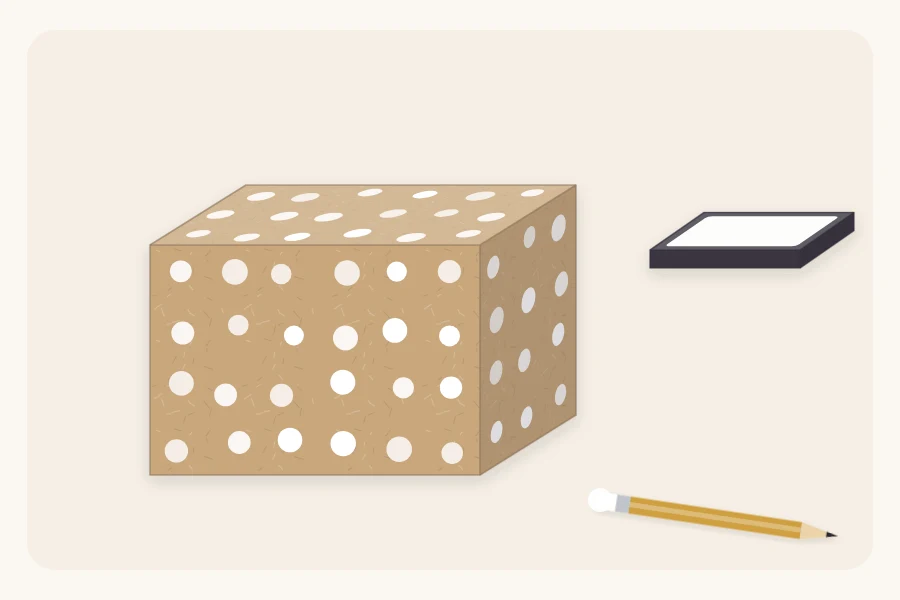 A kraft-wrapped box stamped with white dots beside a pencil with an eraser tip and an ink pad