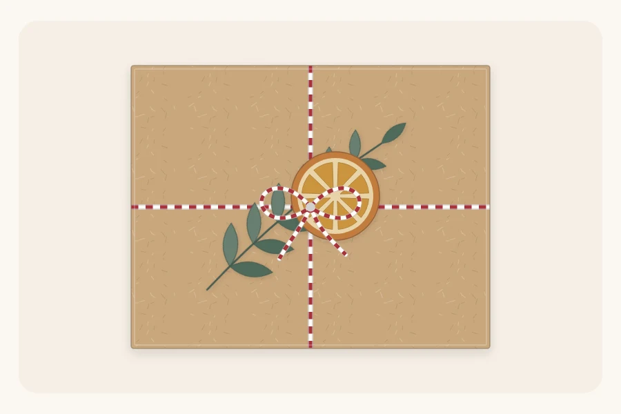 A kraft-wrapped box tied with baker's twine holding a greenery sprig and a dried orange slice