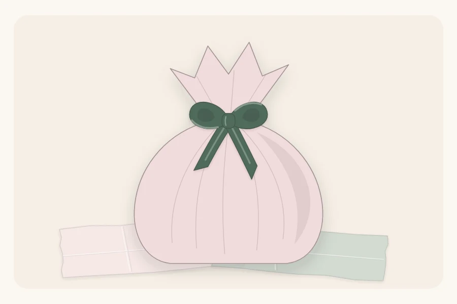 A soft gift wrapped in tissue gathered at the top and tied with ribbon like a pouch