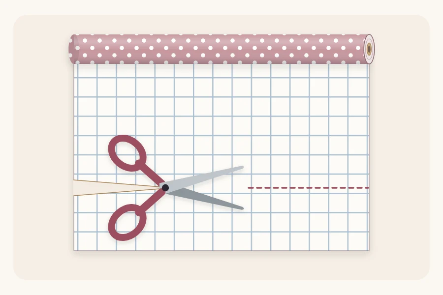 The back of a wrapping paper sheet with a printed grid and scissors cutting along a line